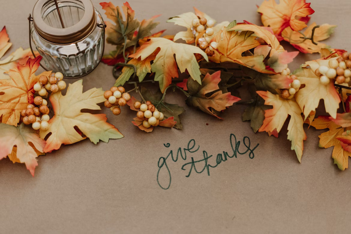 autumn leaves, jar and give thanks written on a paper