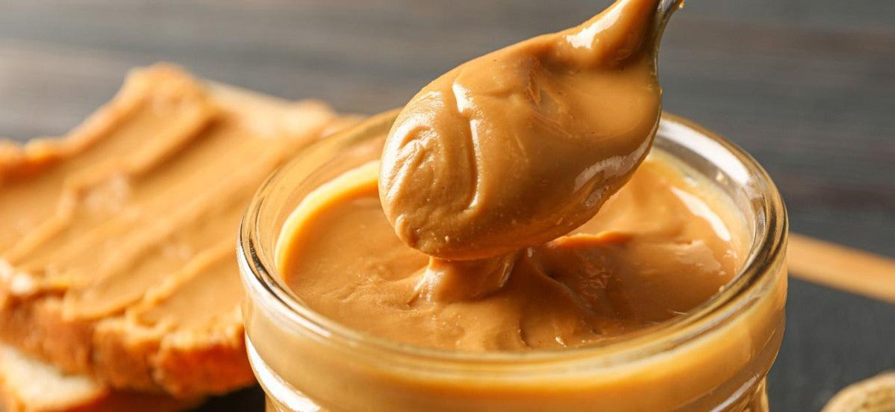 spoon next to a jar with nut butter